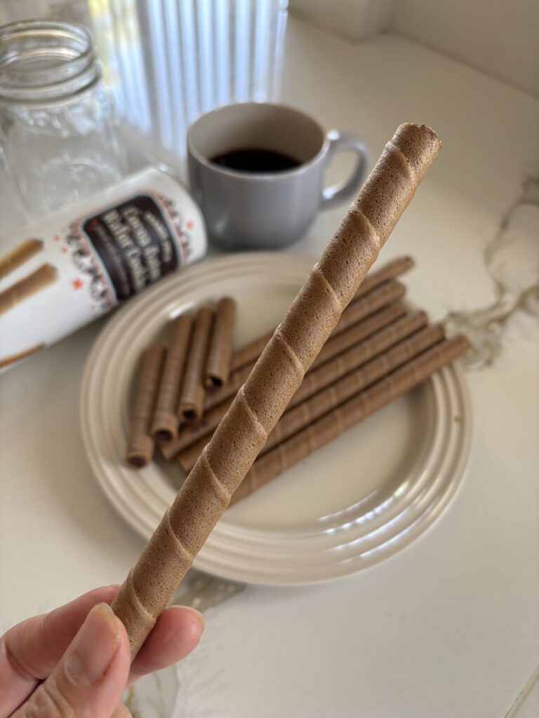 Trader Joe’s Cocoa Baton Wafer Cookiesを1本手に持った実食シーンの写真