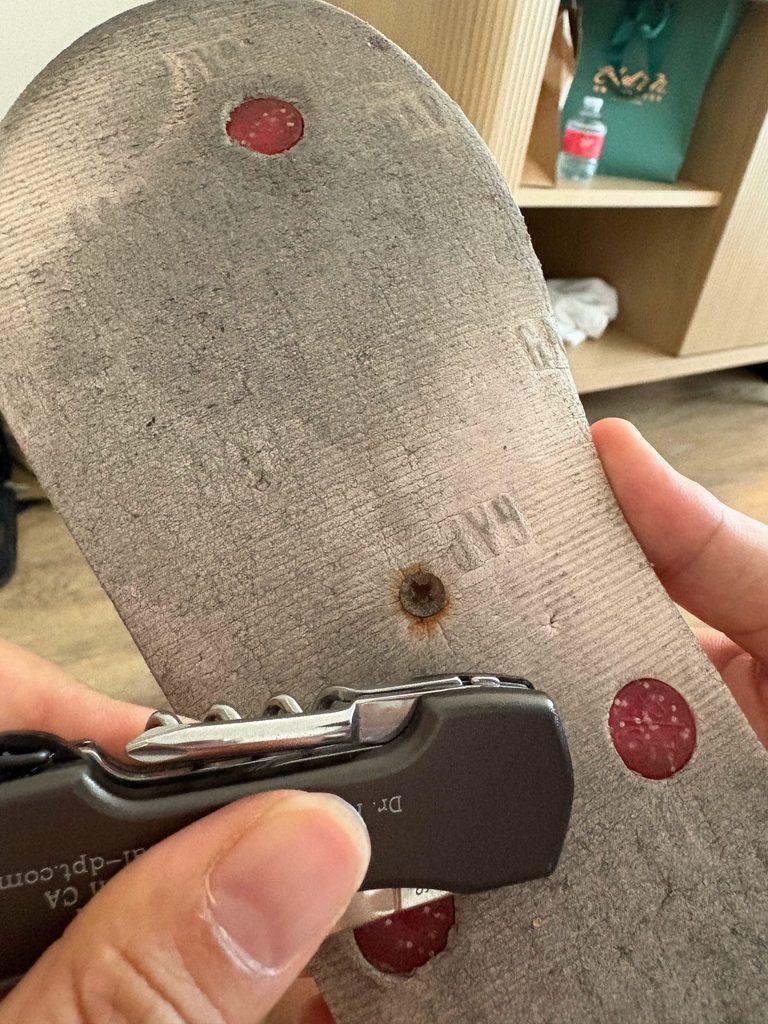 サンダルの裏の土踏まずあたりにネジが刺さっている様子